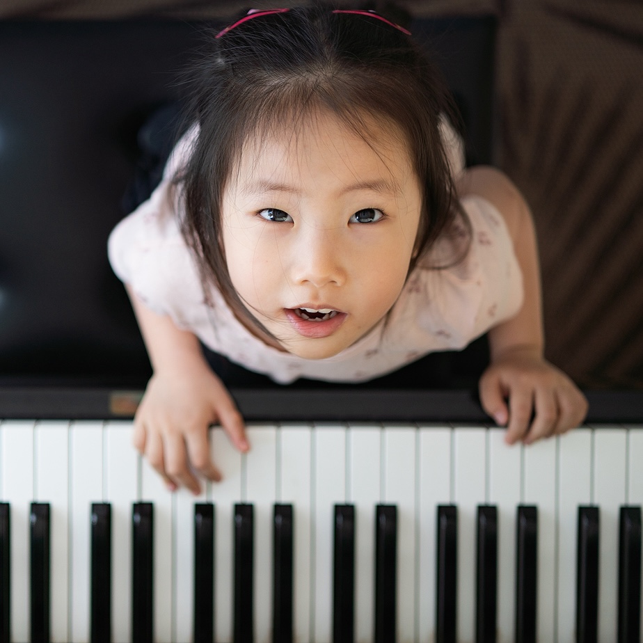 Photo of girl looking up from playing piano